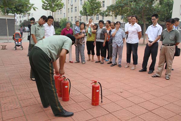 寒亭區(qū)消防隊(duì)隊(duì)長(zhǎng)為城市經(jīng)典小區(qū)居民講解滅火器使用方法